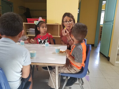 preschool teacher eating with students