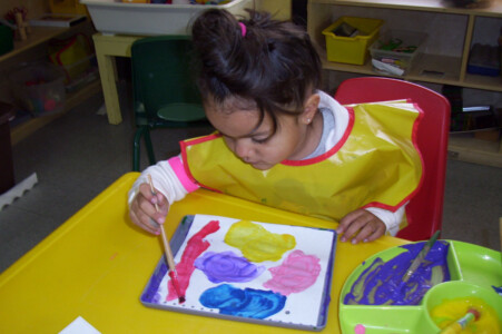 3 year old girl painting at daycare