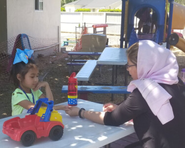 teacher talking with child on the playground