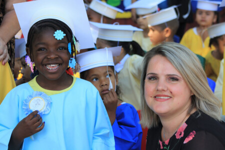 teacher smiling with pre-k graduate